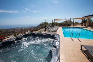 a swimming pool with a hot tub at Hills View Villa in Kathikas