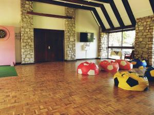 Zimmer mit Holzboden mit roten und gelben Objekten in der Unterkunft Taita Hills Safari Resort & Spa in Tsavo