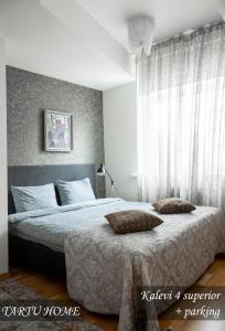 a bedroom with two beds and a large window at City Center Turu str apartments, parking, Tartu Home in Tartu