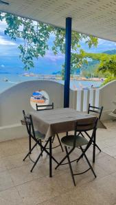 a table and chairs with a view of a beach at Chom By The Sea in Ao Nam Mao