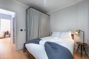 a bedroom with a bed with white sheets and a window at Trendy London Home GS1 in London