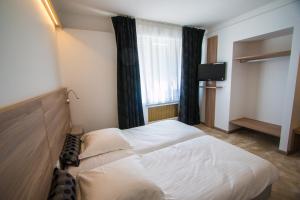 
a bedroom with a bed and a desk at Hotel Les Voyageurs in Modane
