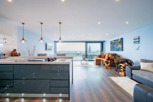 a kitchen and living room with a couch at Beach View Breeze Family Holiday Home on the Shore in Pevensey