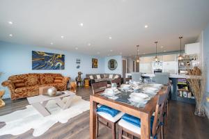 a kitchen and living room with a table and a couch at Beach View Breeze Family Holiday Home on the Shore in Pevensey