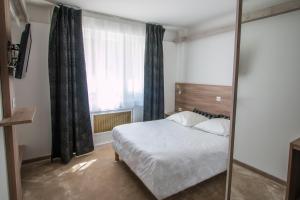 a bedroom with a bed and a large window at Hotel Les Voyageurs in Modane