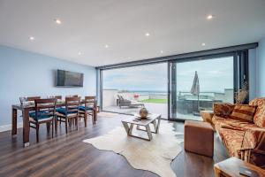 a living room with a couch and a table and a dining room at Beach View Breeze Family Holiday Home on the Shore in Pevensey