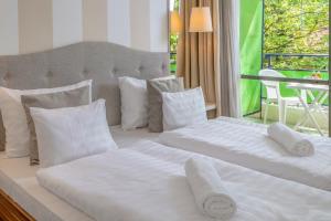 a bedroom with two beds with white sheets and pillows at Vénusz Hotel in Siófok