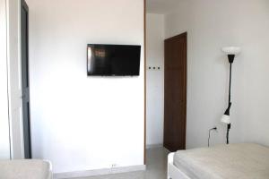 - une chambre dotée d'une télévision sur un mur blanc dans l'établissement Farm Stay Herbarium Citra 011026-LT-0076, à Santo Stefano di Magra