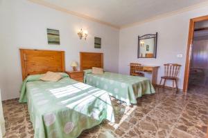 um quarto com 2 camas, uma mesa e um espelho em Villa Tossals em Xàbia