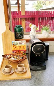 a table with a coffee maker and a box of cookies at Beach Garden Getaway in Cheltenham