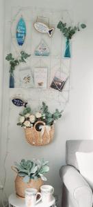 deux paniers sur un mur avec des plantes et des tasses dans l'établissement Beach Garden Getaway, à Cheltenham
