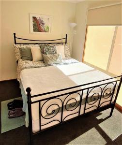 ein Schlafzimmer mit einem großen Bett mit Kissen in der Unterkunft Beach Garden Getaway in Cheltenham