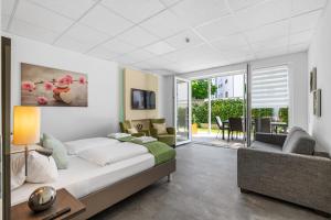 フリードリヒスハーフェンにあるFerien & Business Apartments Hotel Adlerのベッドルーム1室(ベッド1台付)、リビングルームが備わります。