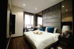 1 dormitorio con 1 cama blanca grande con almohadas azules en 8 KIA Peng, en Kuala Lumpur