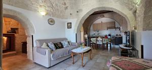 a living room with a couch and a kitchen at Trulli Giovanni e Angela in Locorotondo
