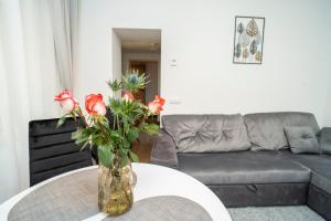 a vase with flowers on a table in a living room at Downhill Apartment on the Groundfloor in Kaunas +23 photos