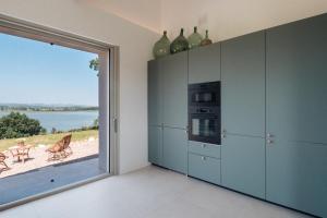cocina con ventana grande con vistas al agua en Il Gruccione Lago di Montepulciano Private Pool Stunning Views, en Binami