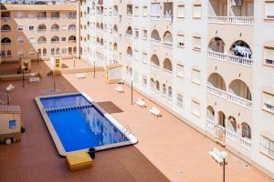 a large building with a swimming pool in a courtyard at San Pascual ID91 in Torrevieja
