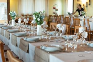 een lange tafel met witte borden en bloemen erop bij Parco Donnortei in Fonni