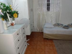 a bedroom with a white dresser and a bed at G's Nest Bed and Breakfast in Vieux Fort