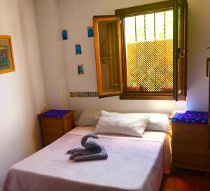 1 dormitorio con 2 camas y ventana en CUEVA EL DUENDE en Granada