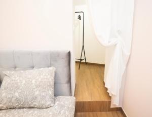 a white couch with a pillow next to a window at Downhill Apartment on the Groundfloor in Kaunas