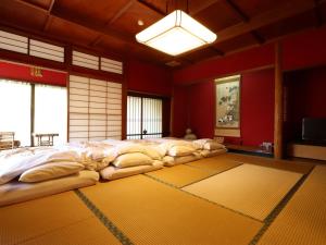 a large bed in a room with red walls at Ryokan Karasawa in Kanazawa
