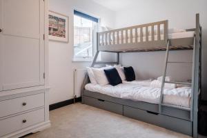 a bedroom with two bunk beds and a dresser at Holiday Home Churchfields - Stunning Views in Dartmouth