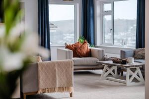 a living room with a couch and a table at Holiday Home Churchfields - Stunning Views in Dartmouth