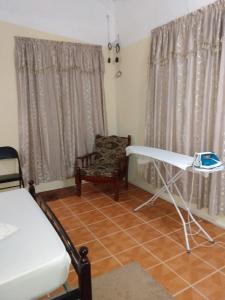 Zimmer mit einem Bett, einem Tisch und einem Stuhl in der Unterkunft G's Nest Bed and Breakfast in Vieux Fort
