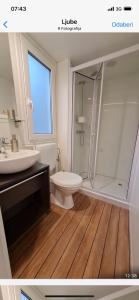 een badkamer met een douche, een toilet en een wastafel bij OAZA MIRA 2 Mobile House - Camp Baško Polje in Baška Voda