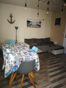 a living room with a table and a couch at Proche du centre ville in La Rochelle