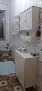 a white kitchen with a sink and a toilet at Sa Prenda E Oro in Ulà Tirso +62 photos