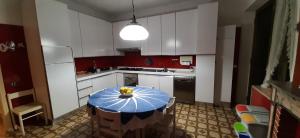 a kitchen with a table with a bowl of fruit on it at Sa Prenda E Oro in Ulà Tirso +66 photos