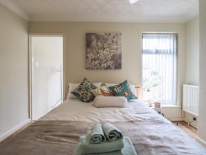 a bedroom with a large bed with towels on it at 122 Morton Road in Lowestoft