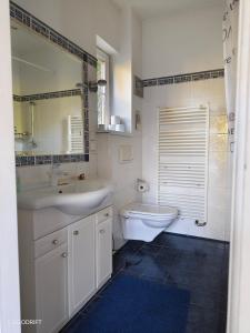 a bathroom with two sinks and a toilet and a mirror at Charmantes Haus mit Terrasse und großem Garten in Langenzersdorf