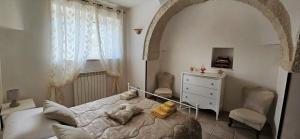 Un dormitorio con una cama y una silla y una ventana. en Trulli Giovanni e Angela, en Locorotondo 21 fotos más