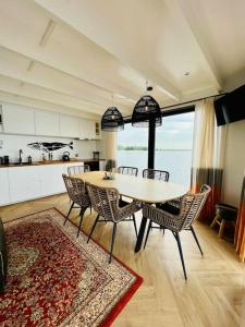 een eetkamer met een tafel en stoelen in een keuken bij Surla Houseboat "Walvis" Kagerplassen with tender 