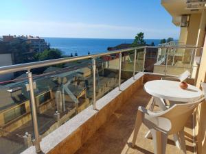 balcón con mesa y vistas al océano en Golden House Apartments, en Golden Sands