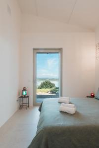 1 dormitorio con cama y ventana grande en Il Gruccione Lago di Montepulciano Private Pool Stunning Views, en Binami