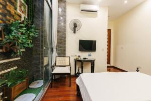 a bedroom with a bed and a desk and a tv at Sun Clover Boutique Hotel in Hanoi