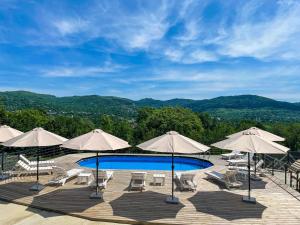 a swimming pool with chairs and umbrellas at Moon Village Comarnic in Sinaia