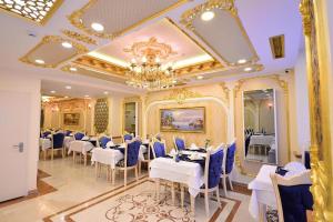 uma sala de jantar com mesas brancas e cadeiras azuis em Golden Marmara Hotel em Istambul