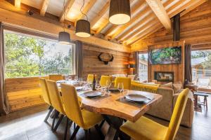 a dining room with a table and chairs and a fireplace at Ruggine - Forêt, luxe et montagne in Bolquere Pyrenees 2000