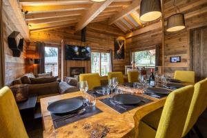 a dining room with a large wooden table and chairs at Ruggine - Forêt, luxe et montagne in Bolquere Pyrenees 2000