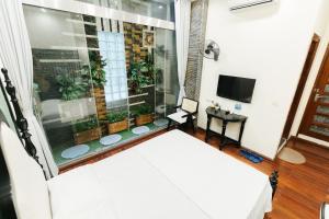 um quarto com uma cama e uma janela com plantas em Sun Clover Boutique Hotel em Hanói