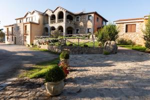 una grande casa in pietra con piante in vaso di fronte ad essa di Parco Donnortei a Fonni