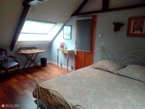 1 dormitorio con cama, ventana y mesa en vive les vacances, en Gausson