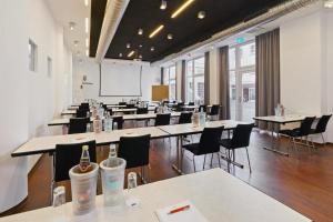 a large room with tables and chairs with bottles on them at Townhouse Düsseldorf in Düsseldorf