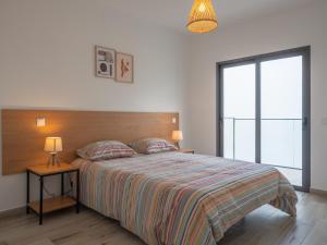 - une chambre avec un lit et une table de chevet avec deux lampes dans l'établissement Surfer’s Pitstop, à Aljezur